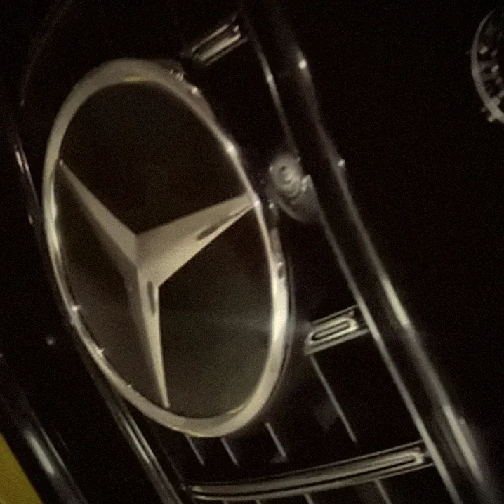 Close-up of a black Mercedes grille and star emblem at night